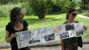Two young women hold up their community timeline creation