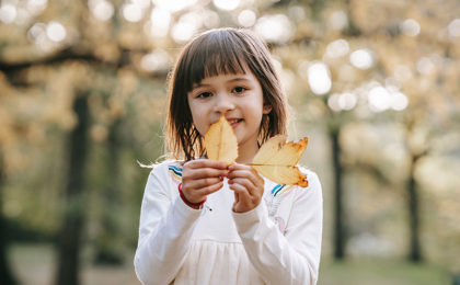 young girl holding leaves