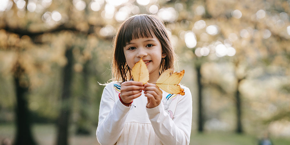 young girl holding leaves