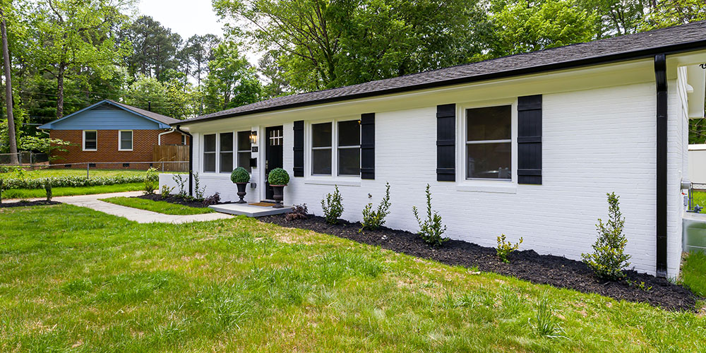 white bungalow with trees on property