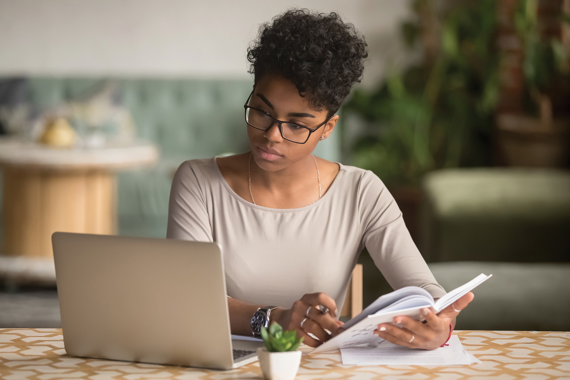Women sits in front of a laptop reviewing curriculum materials