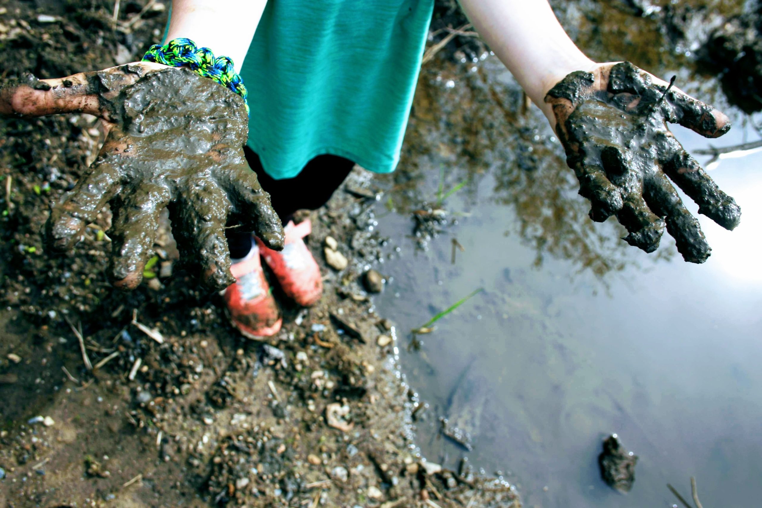 child showing their muddy hands