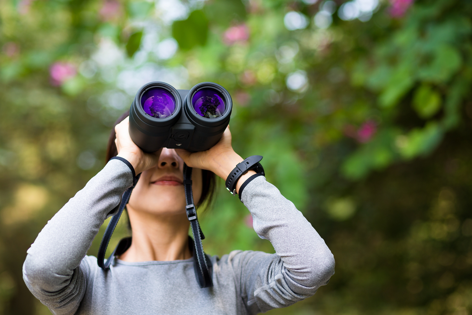 Young girl looking though binocular in jungle