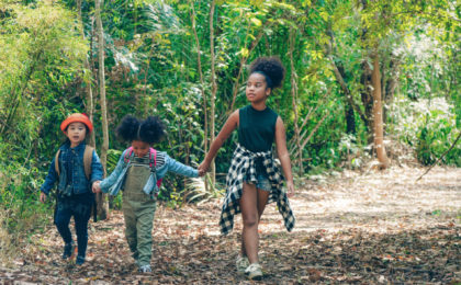African american children having fun walking together in forest