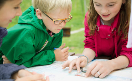 elementary students using navigation tools outdoors