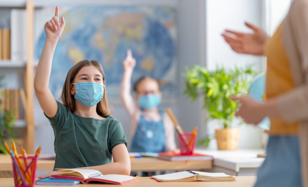 Kids wearing facemasks learning in class
