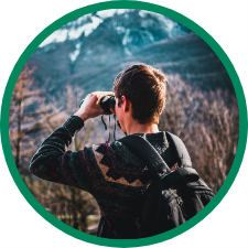 young man looks through a pair of binoculars