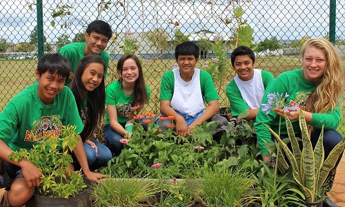 students-gather-around-school-pollinator-garden