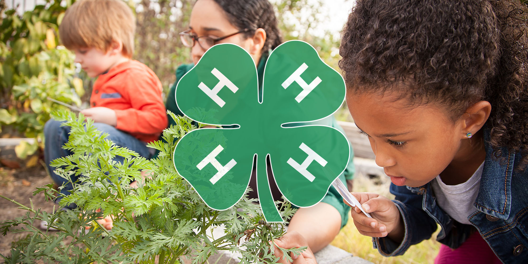 A young girl examines a herb garden with a magnifyer