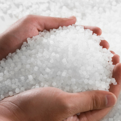 Hands holding thousands of plastic pellets smaller than 5 millimeters