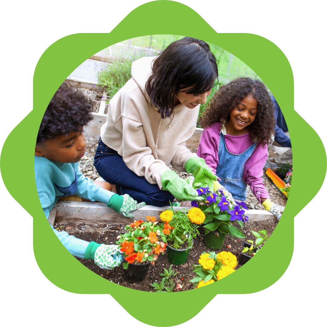 teacher and 2 young children around gardening bed