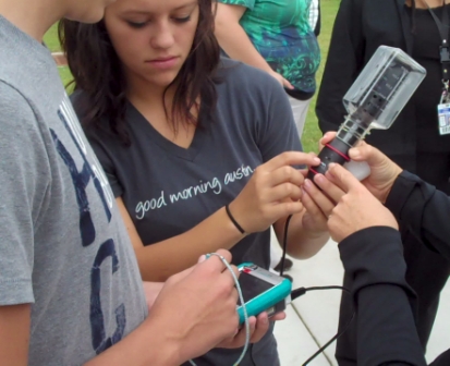 Older children conducting an outdoor experiment using a CO2 meter.
