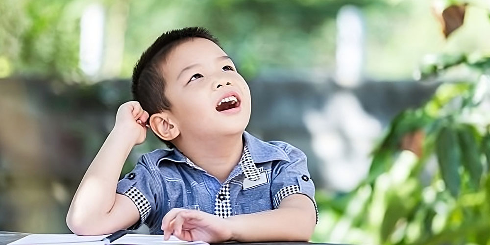 a young boy gazing up at a plant in wonder